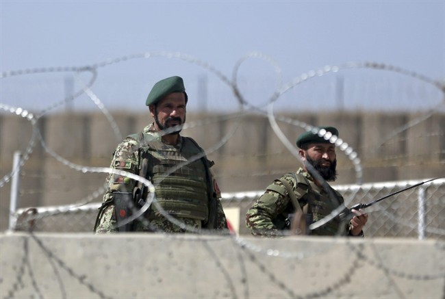 Afghanistan National Army soldiers stand guard at a gate of Camp Qargha, west of Kabul, Afghanistan, Tuesday, Aug. 5, 2014. 