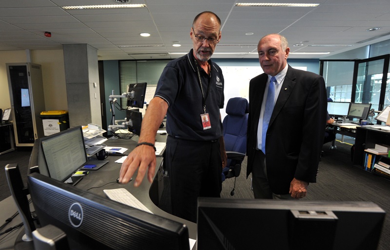 Australian Deputy Prime Minister Warren Truss, right, talks with John Rice, senior search and rescue officer and mission coordinator for the search for the missing Malaysia Airlines Flight MH370, at rescue coordination center of the Australian Maritime Safety Authority in Canberra. (AP Photo/Graham Tidy, Pool) .