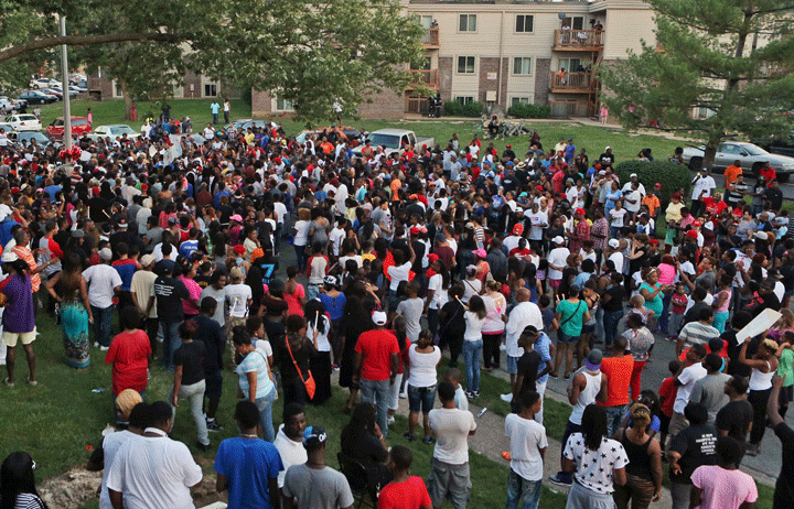 A large crowd gathers at the candlelight vigil, Sunday evening, Aug. 10, 2014, in Ferguson, Mo.