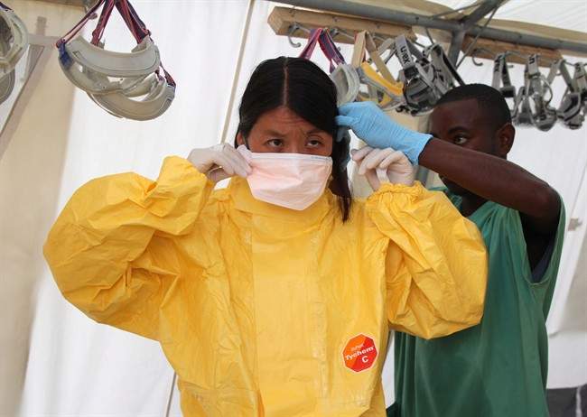 Dr. Joanne Liu, international president of Medecins Sans Frontieres (Doctors Without Borders) puts on a mask as she visits the Ebola treatment centre in Kailahun, Sierra Leone in this recent handout photo. 