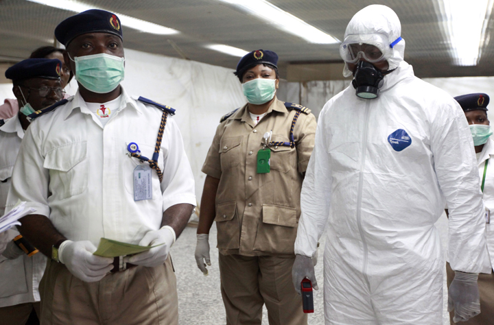 Nigerian health officials wait to screen passengers at the arrivals hall of Murtala Muhammed International Airport in Lagos, Nigeria, Monday, Aug. 4, 2014. 