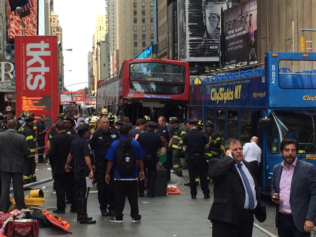 In this photo provided by tracedinc.com, people look as emergency personnel respond to a bus crash on Tuesday, Aug. 5, 2014, in New York City's Times Square.