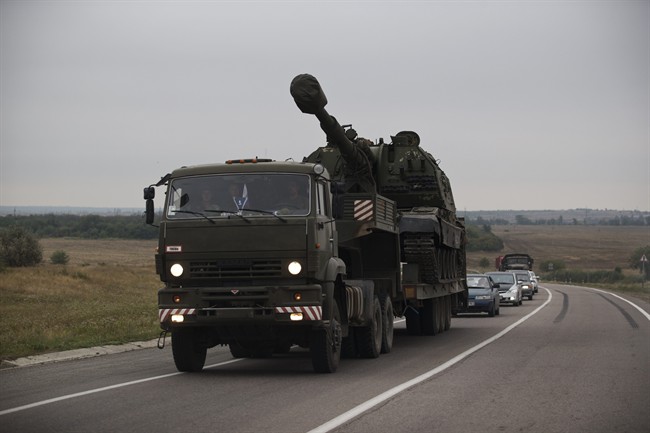 A Russian military truck carries a MSTA-S self-propelled howitzer about 10 kilometers from the Russia-Ukrainian border control point at town Donetsk, Rostov-on-Don region, Russia, Tuesday, Aug. 19, 2014. (AP Photo/Pavel Golovkin).