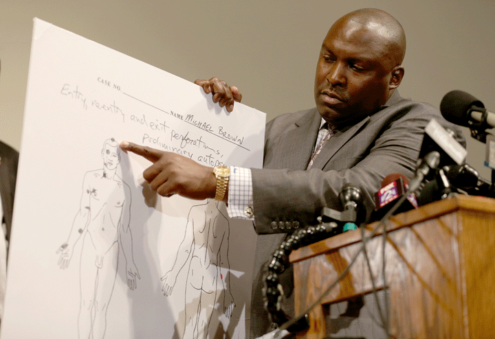 Family attorney for Michael Brown, Daryl Parks, points to an autopsy diagram showing where the gun shots hit Michael Brown during a press conference at the Greater St. Marks Family Church on August 18, 2014 in Ferguson, Missouri.
