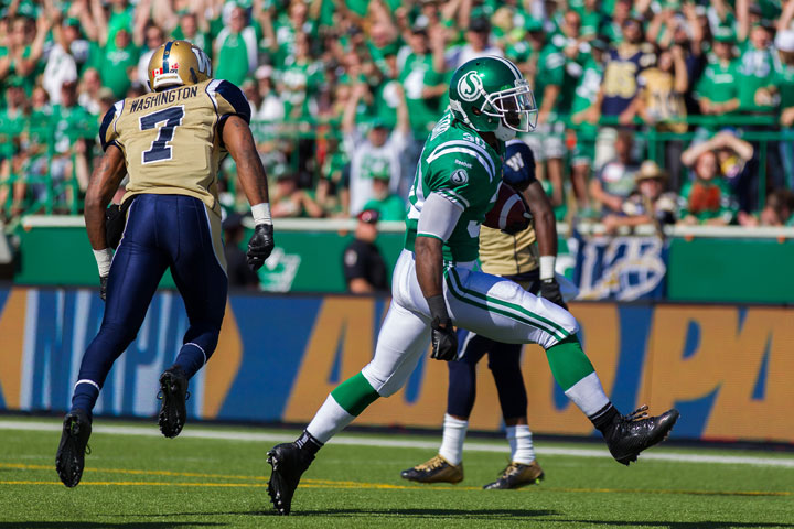 Will Ford #30 of the Saskatchewan Roughriders high steps into the end zone for a touchdown in front of Demond Washington #7 of the Winnipeg Blue Bombers in a game between the Winnipeg Blue Bombers and Saskatchewan Roughriders in week 10 of the 2014 CFL season at Mosaic Stadium on August 31, 2014 in Regina, Saskatchewan.