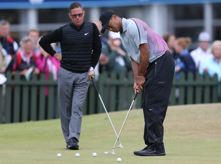 In this July 16, 2014 file photo, Tiger Woods is watched by coach Sean Foley on the practice green ahead of the British Open Golf championship at the Royal Liverpool golf club in, Hoylake, England. 