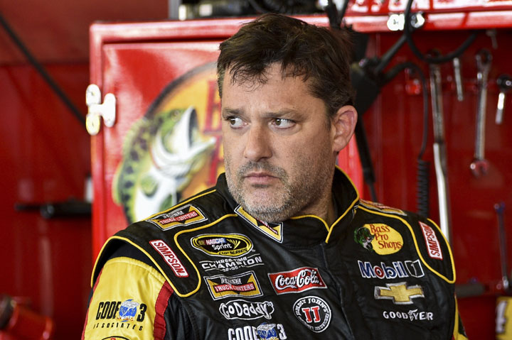 In this Friday, Aug. 8, 2014 photograph, Tony Stewart stands in the garage area after a practice session for Sunday's NASCAR Sprint Cup Series auto race at Watkins Glen International, in Watkins Glen N.Y. 