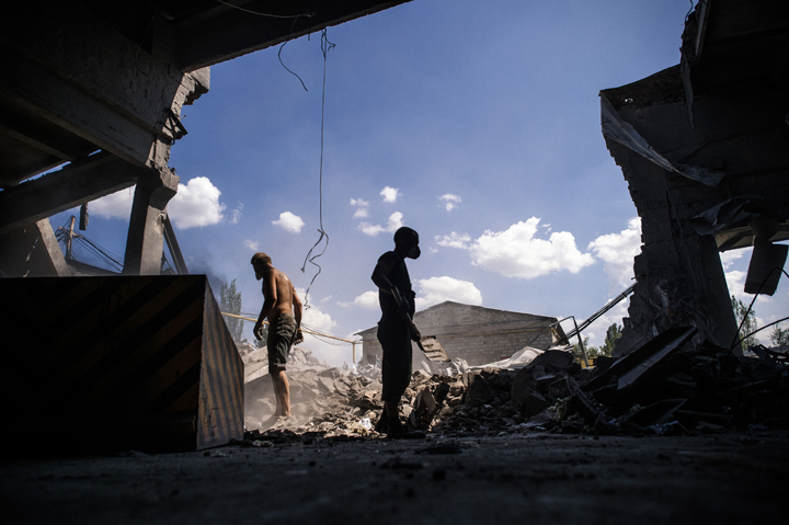 Men clean debris outside a store after an 'air strike' overnight in Donetsk, on August 6, 2014. The main rebel stronghold of Donetsk in east Ukraine was hit by an 'air strike' overnight that caused no civilian casualties, local authorities said Wednesday.