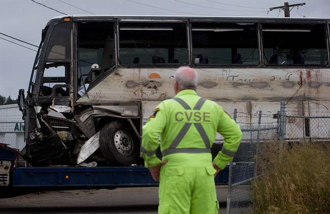File photo; A Commercial Vehicle Safety and Enforcement officer watches as a tour bus that rolled over and crashed on the Coquihalla Highway south of Merritt, B.C. August 28th. 