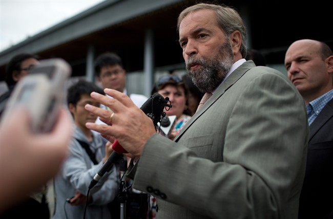 NDP Leader Thomas Mulcair responds to questions as MP Nathan Cullen, right, listens during a media availability in Vancouver, B.C., on Tuesday August 19, 2014.