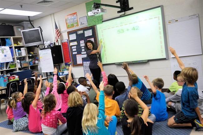 FILE - In this Oct. 1, 2013, file photo, a third grade teacher teaches a math lesson to her students.