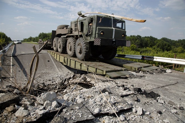 A Ukrainian army military vehicle travels across a damaged bridge near the village of Debaltseve, Donetsk region, eastern Ukraine, Thursday, July 31, 2014.