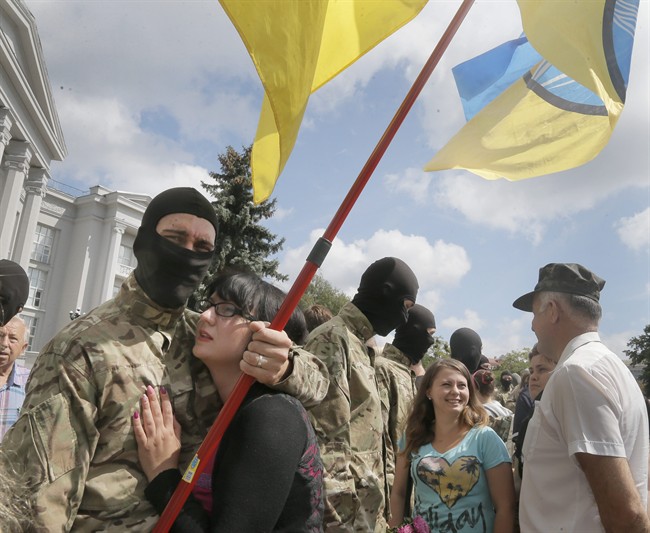 Friends and relatives say goodbye to volunteers before they were sent to the eastern part of Ukraine to join the ranks of special battalion "Azov" fighting against pro-Russian separatists, in Kyiv, Ukraine, Sunday, Aug. 17, 2014.