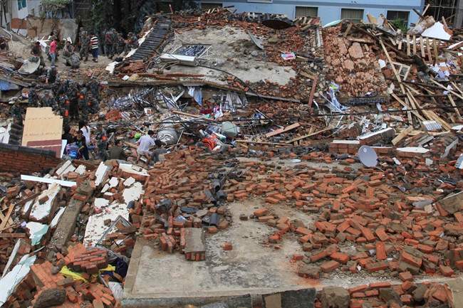 Rescue workers search for survivors amongst the remains of collapsed buildings in the epicenter of an earthquake that struck the town of Longtoushan in Ludian county in southwest China\’s Yunnan province Monday, Aug. 4, 2014.