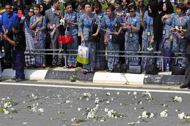 Flowers are laid along a roadside after hearses carrying victims' bodies of the ill-fated Malaysia Airlines Flight MH17 leaved Bunga Raya Complex at Kuala Lumpur International Airport in Sepang, Malaysia, Friday, Aug. 22, 2014.