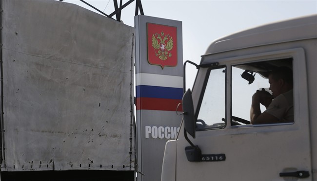 Trucks marked as being from a bitterly disputed Russian aid convoy to Ukraine stand in line as they return to Russia in the Russian town of Donetsk, Rostov-on-Don region, Russia, Saturday, Aug. 23, 2014.