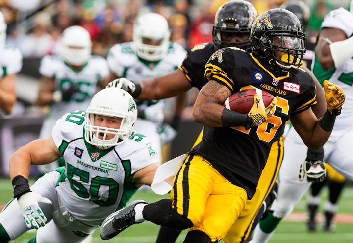 Hamilton Tiger-Cats running back Mossis Madu, right, runs the ball past Saskatchewan Roughriders linebacker Chad Kilgore, left, during the first half of their CFL game at Tim Hortons Field in Hamilton, Ont., Sunday, September 14, 2014.
