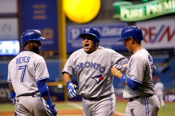 Dioner Navarro #30 of the Toronto Blue Jays (C) celebrates his two-run home run with teammates Jose Reyes #7 and Ryan Goins #17 during the eighth inning of a game on September 2, 2014 at Tropicana Field in St. Petersburg, Florida.  (Photo by Brian Blanco/Getty Images).