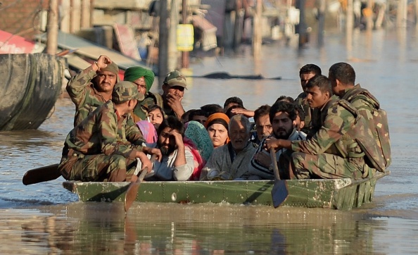Flood-affected Kashmiri residents ride on an Indian Army raft in Srinagar on September 11, 2014. The floods and landslides from days of heavy monsoon rains have now claimed more than 450 lives in Pakistan and India, with hospitals struggling to cope with the disaster.  