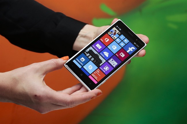 A woman shows the new Lumia 830 smart phone during a Microsoft Nokia presentation event at the consumer electronic fair IFA in Berlin.