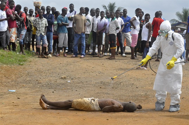 Health-care worker sprays man with disinfectant chemicals in Monrovia, Liberia.
