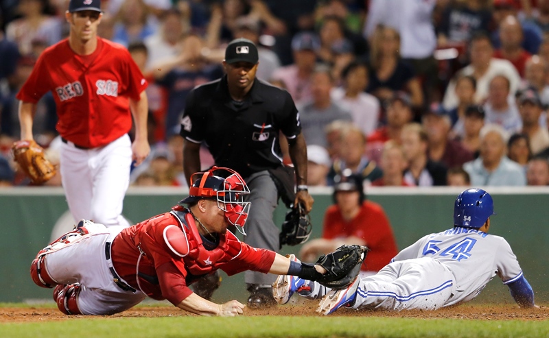 Christian Vazquez #55 of the Boston Red Sox is late with the tag as Marcus Stroman #54 of the Toronto Blue Jays scores the go ahead run in the 10th inning against the Boston Red Sox at Fenway Park on September 5, 2014 in Boston, Massachusetts. (Photo by Jim Rogash/Getty Images).