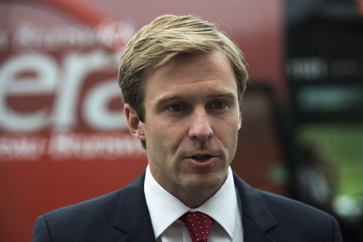 New Brunswick Liberal leader Brian Gallant talks with reporters near his campaign bus in Dieppe, N.B. on Aug. 21, 2014.