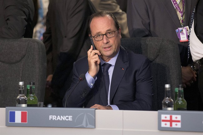 French President Francois Hollande holds a phone at the start of a NATO-Afghanistan round table meeting in Newport, Wales on Thursday, Sept. 4, 2014. 