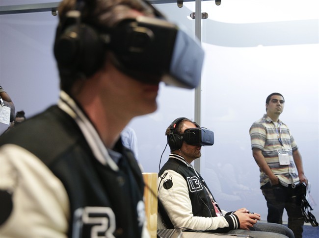 Show attendees play a video game with Oculus Rift virtual reality headsets at the Electronic Entertainment Expo, in Los Angeles.