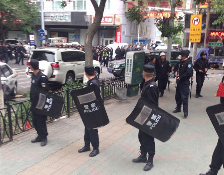 In this photo released by China's Xinhua News Agency, police officers stand guard near a blast site which has been cordoned off, in downtown Urumqi, capital of northwest China's Xinjiang Uygur Autonomous Region, Thursday, May 22, 2014. 