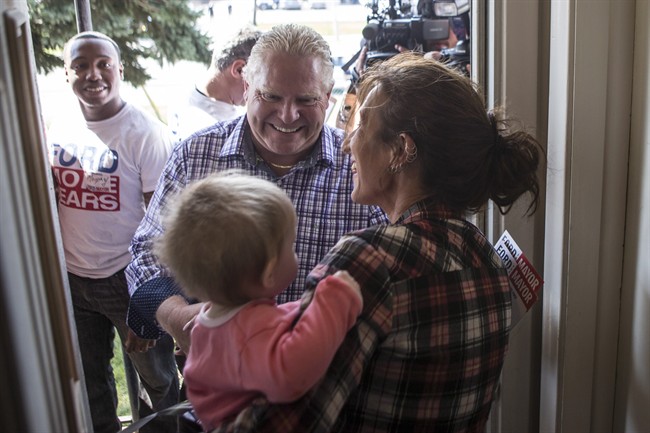 Toronto mayoral candidate Doug Ford (centre) greets Vicki Crystal and her ten-month-old grand daughter Elena as he starts his campaign by door knocking in his local Etobicoke neighbourhood of Toronto on Saturday, September 20, 2014. 
