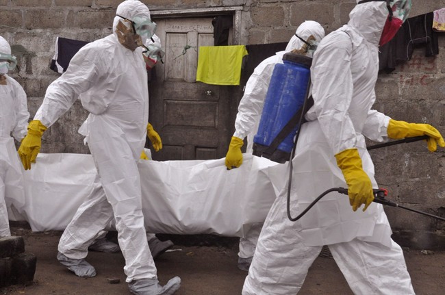 Health workers carry the body of a woman that they suspect died from the Ebola virus, in an area known as Clara Town in Monrovia, Liberia, Wednesday, Sept. 10, 2014. 
