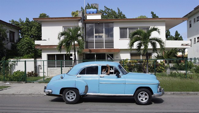 In this Friday Nov. 18, 2011 photo, a classic car drives in front of the headquarters of the firm Coral Capital Group in Havana. The government has given no information on probes of the investment firm Coral Capital Group, led by a Briton, Tri-Star Caribbean and Tokmakjian Group, two car dealerships run by Canadians. 