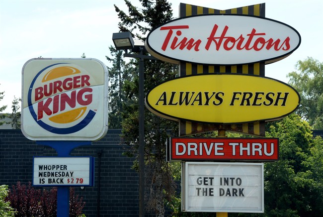 A Burger King sign and a Tim Hortons sign are displayed in Ottawa on August 25, 2014. THE CANADIAN PRESS/Sean Kilpatrick