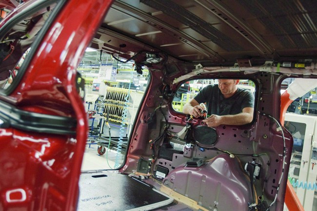 A worker installs parts on the production line at a Chrysler plant in Windsor. Torrid auto sales in the United States has pushed export sales from Canada to a record high.