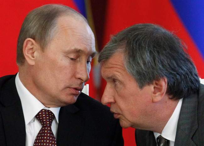Russian President Vladimir Putin, left, and CEO of state-controlled Russian oil company Rosneft Igor Sechin speak during a signing ceremony of cooperation agreements with Venezuelan President Nicolas Maduro in the Kremlin in Moscow, Tuesday, July 2, 2013. 