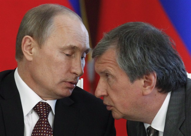 Russian President Vladimir Putin, left, and CEO of state-controlled Russian oil company Rosneft Igor Sechin speak during a signing ceremony of cooperation agreements with Venezuelan President Nicolas Maduro in the Kremlin in Moscow, Tuesday, July 2, 2013. 
