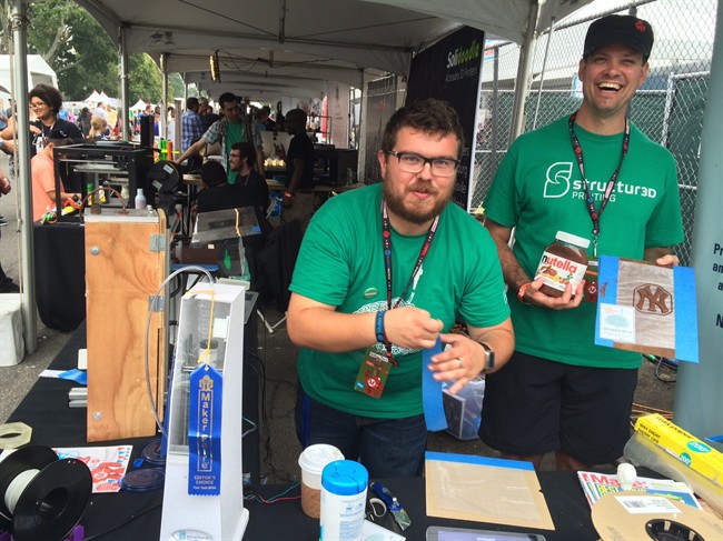 Andrew Finkle and Charles Mire, the co-founders of Canadian startup Structur3D, show off the 3D printer adapter they used to create a New York Yankees logo out of Nutella at the Maker Faire festival in Queens, N.Y., on Sept. 21, 2014.