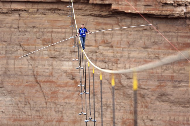 In this June 23, 2013 file photo provided by the Discovery Channel, aerialist Nik Wallenda walks a 2-inch-thick steel cable taking him a quarter mile over the Little Colorado River Gorge, Ariz. On Tuesday, Sept. 16, 2014, Wallenda said that his next tightrope walk will be more than 50 stories high from one high-rise building to another over the Chicago River.