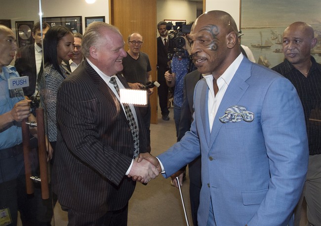 Toronto Mayor Rob Ford, centre, shakes hands with former heavyweight boxing champion Mike Tyson at City Hall in Toronto on Tuesday, September 9, 2014. 
