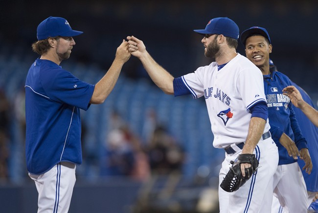 Toronto Blue Jays, from left to right, R.A. Dickey, Brandon Morrow, and Marcus Stroman celebrate the Blue Jays' 11-1 win over the Chicago Cubs during MLB baseball action in Toronto on Wednesday, September 10, 2014. THE CANADIAN PRESS/Darren Calabrese.