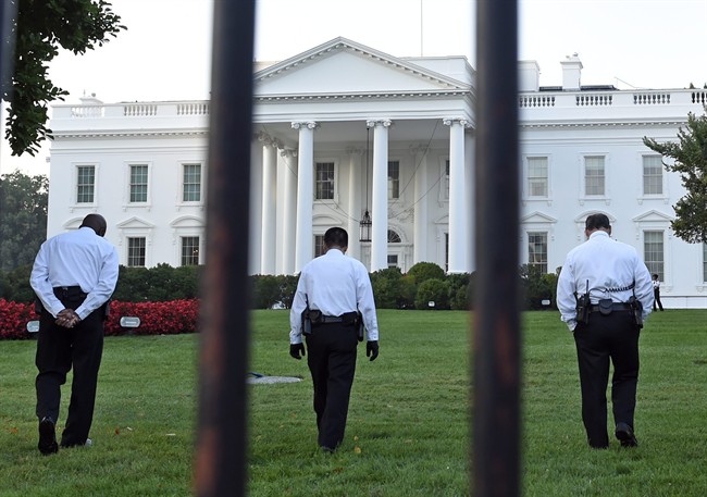 Uniformed Secret Service officers walk along the lawn on the North side of the White House in Washington, Saturday, Sept. 20, 2014.