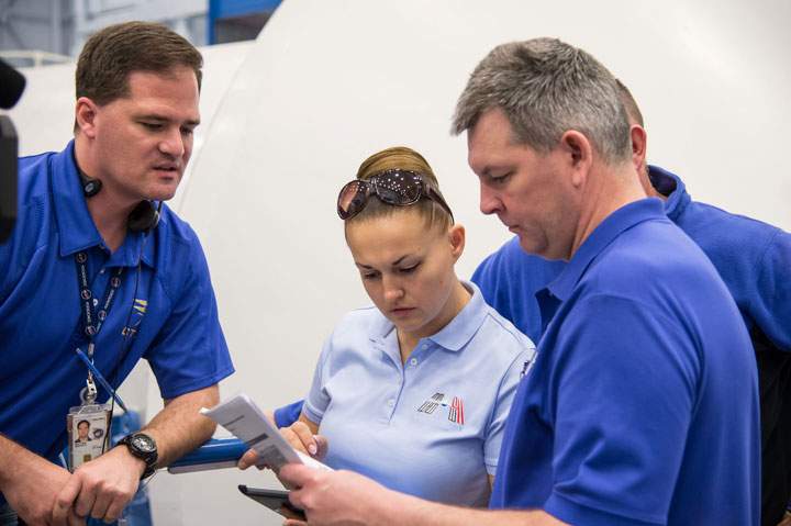 NASA astronaut Barry Wilmore (obscured at right) and Russian cosmonauts Elena Serova and Alexander Samokutyaev (right), participate in a routine operations training session in the Space Vehicle Mock-up Facility at NASA’s Johnson Space Center.