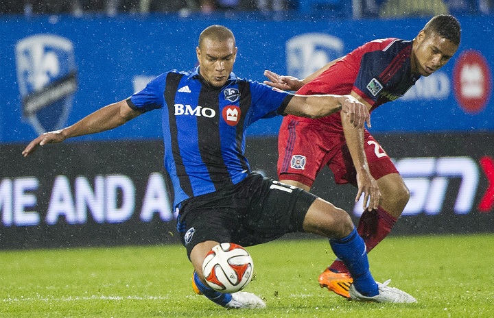 Montreal Impact's Matteo Ferrari, left, and Chicago Fire's Quincy Amarikwa battle for the ball during second half MLS soccer action in Montreal, Saturday, August 16, 2014.