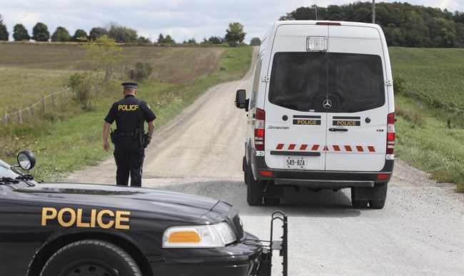 An Ontario Provincial Police van enters the perimeter surrounding the Hullet Conservation Area, northeast of Clinton Ont., Sunday, September 14, 2014.