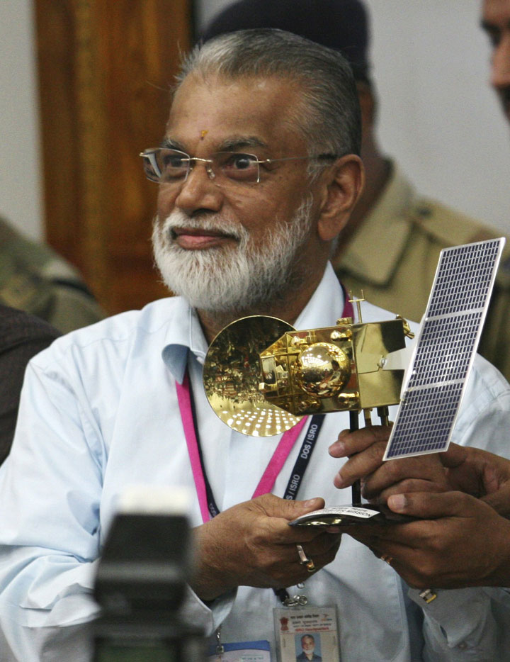 In this Nov. 5, 2013 file photo, Indian Space and Research Organization Chairman, K. Radhakrishnan, poses for the media with a model of the Mars orbiter after its successful launch at Sriharikota, India.