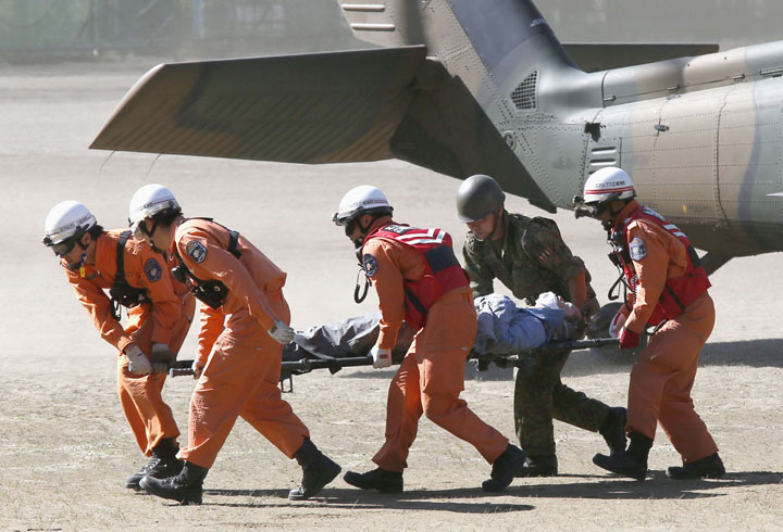 Rescue workers carry a climber rescued from Mount Ontake into an ambulance, in Kiso, Nagano prefecture in central Japan, Sunday, Sept. 28, 2014.