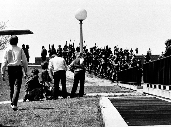 In a May 4, 1970 file photo, a group of students cluster around a wounded person as Ohio National Guardsmen, wearing gas masks, hold their weapons in the background, on Kent State University campus in Kent, Ohio. AP Photo/Douglas Moore