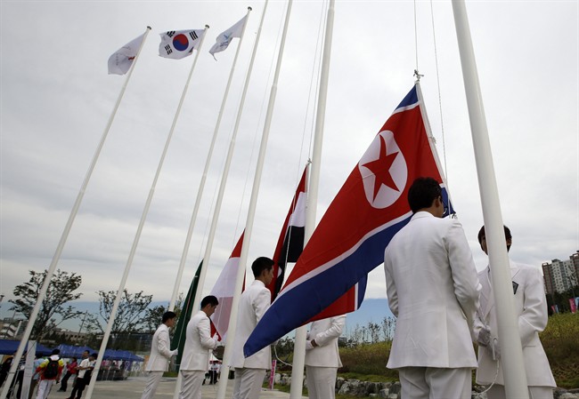 A North Korean flag, right, is prepared for a welcoming ceremony at the Flag Plaza of the Athlete\’s Village for the 2014 Incheon Asian Games in Incheon, west of Seoul, South Korea, Thursday, Sept. 18, 2014.