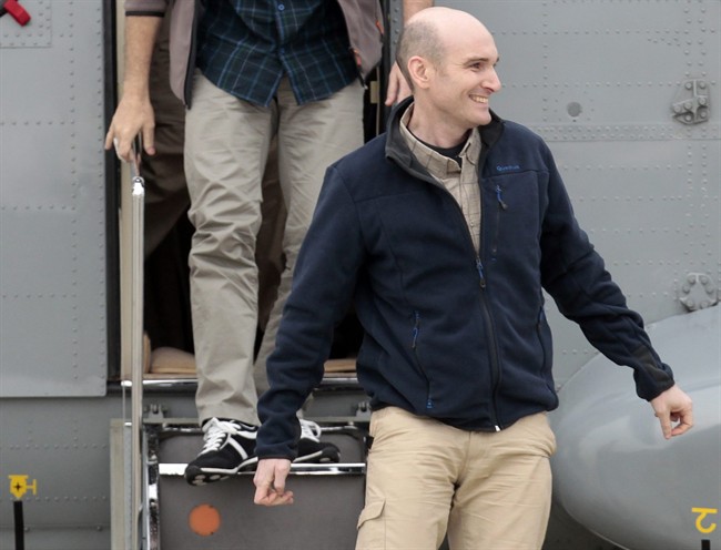 FILE - In this Sunday April 20, 2014 file photo, released French hostage Nicolas Henin arrives at the Villacoublay military airbase, outside Paris. A French journalist held hostage for months by extremists in Syria says one of his captors was a Frenchman suspected of killing four people at the Brussels Jewish Museum earlier this year.
